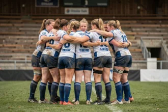 Joueuses de rugby féminin en huddle sur le terrain avant un match de division en France